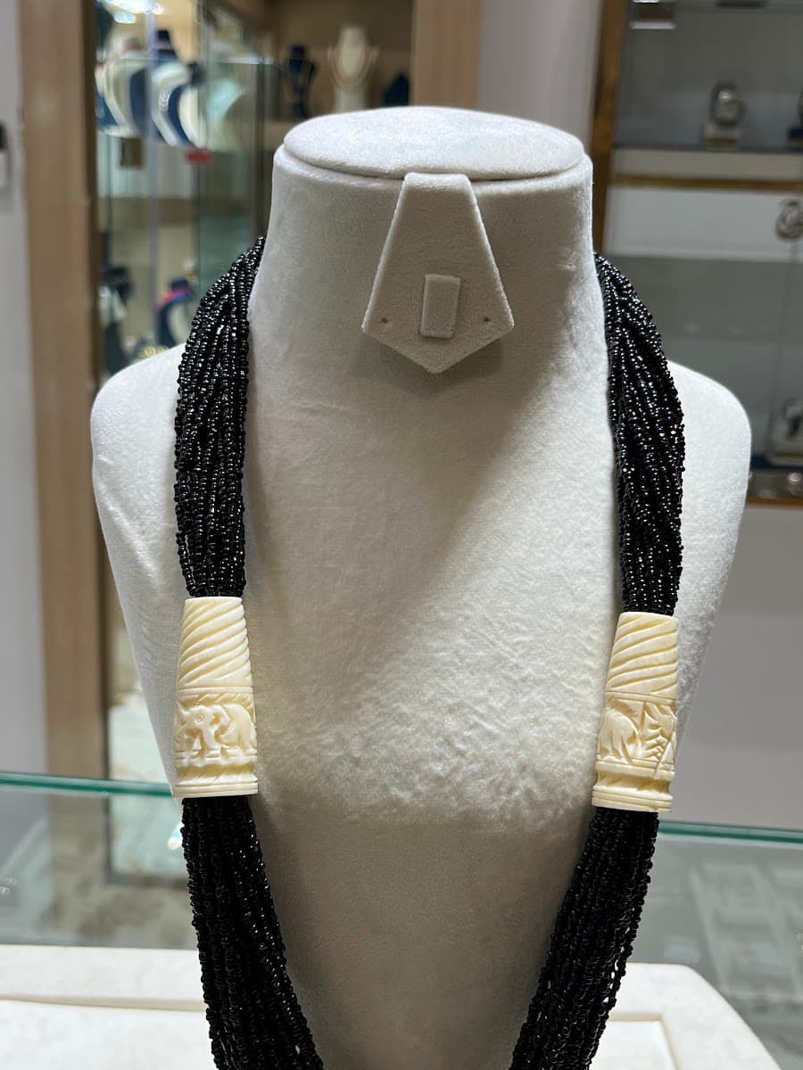 Collier de perles noires avec ornements en ivoire sculpté