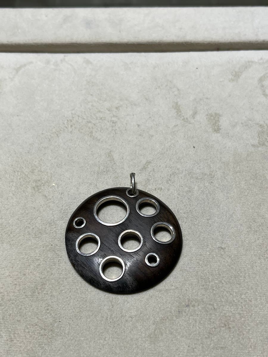 Pendentif rond en bois foncé et argent avec motifs de cercles