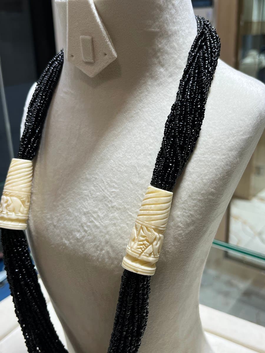Collier de perles noires avec éléments sculptés