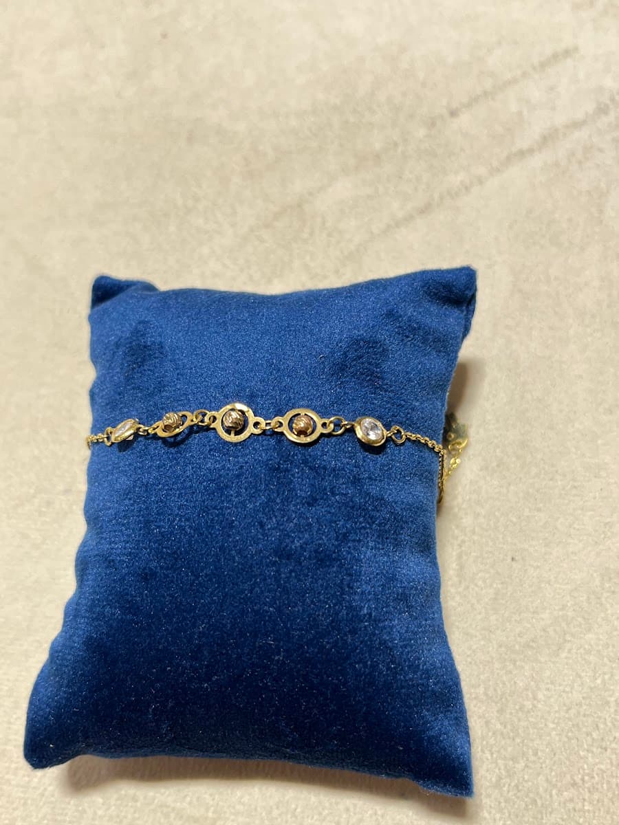 Bracelet en or avec détails circulaires et pierres blanches