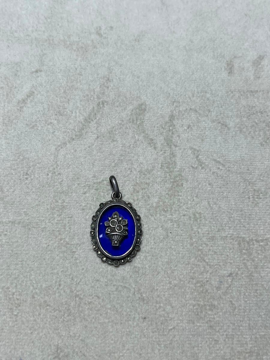 Pendentif argent avec motif floral et fond bleu