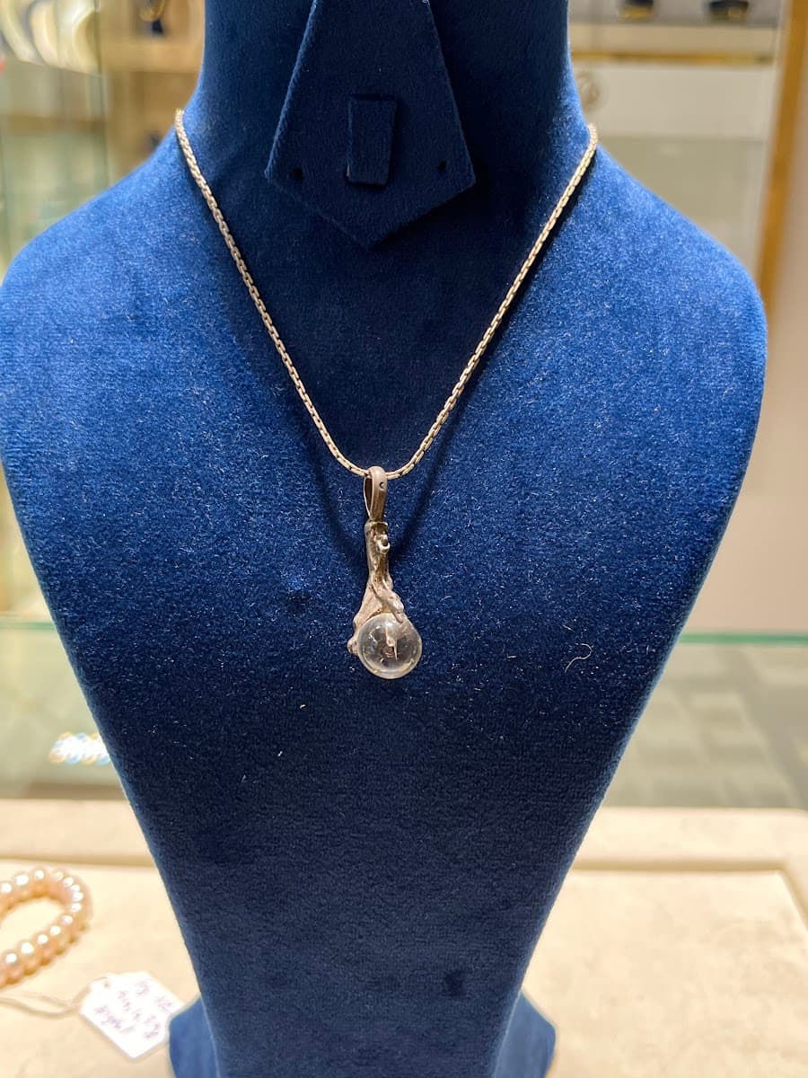 Collier avec pendentif en forme de sphère et monture en métal